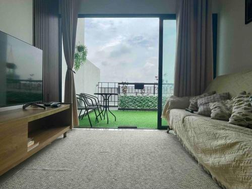 a living room with a couch and a view of a balcony at The Horizon @ Ipoh - Cozy Condo with Balcony Patio in Ipoh