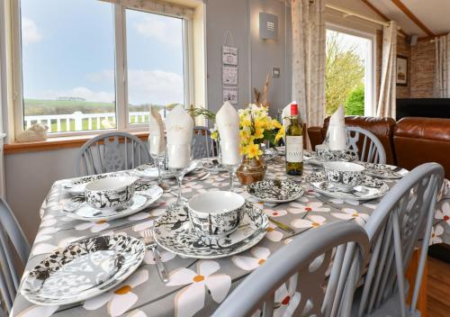 uma mesa de jantar com uma toalha de mesa cinzenta e branca em Lazy Nook em Dinas