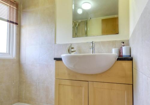 uma casa de banho com um lavatório branco e um espelho. em Lazy Nook em Dinas