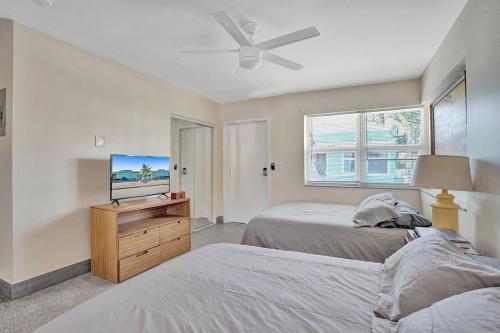 a bedroom with two beds and a flat screen tv at Downtown Hollywood Holiday Retreat Dania Beach in Hollywood