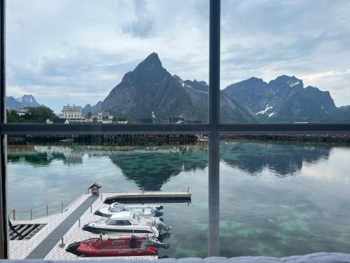a window view of a marina with boats in the water at Rostad Retro Rorbuer in Reine