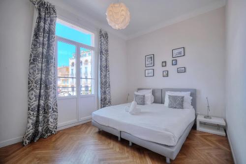 une chambre avec un lit et une grande fenêtre dans l'établissement IMMOGROOM - Palais des festivals within walking distance - balcony - wifi -, à Cannes