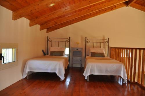 1 Schlafzimmer mit 2 Betten und Holzboden in der Unterkunft Alex 2 Bedroom Apartment in Planos