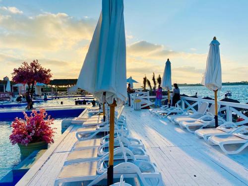 a group of chairs and umbrellas next to a pool at Porto marina chalet and apartment in El Alamein