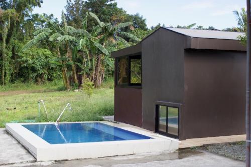 a black house with a swimming pool in a yard at Lorenzo's Farm and Leisure in Santo Tomas