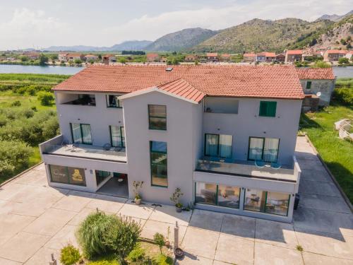 an aerial view of a house with mountains in the background at Boutique rooms Kican in Metković