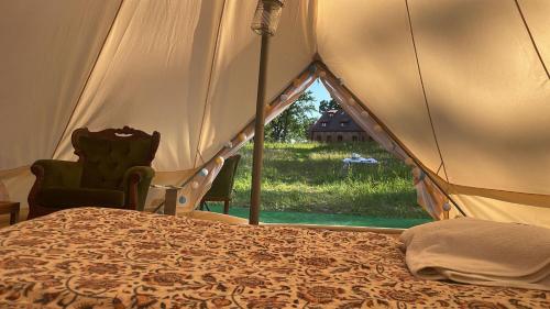 a bed in a tent with a view of a yard at Luxury glamping at Kipeni 