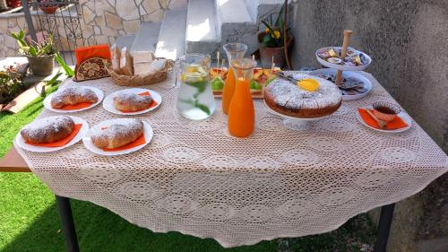 a white table with plates of food and orange juice at B&b Diamante and home restaurant in Trentinara