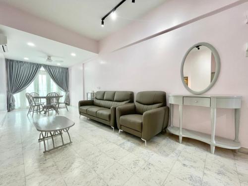 a living room with a couch and a mirror at Century Suria Aparment Langkawi by Zervin in Kuah