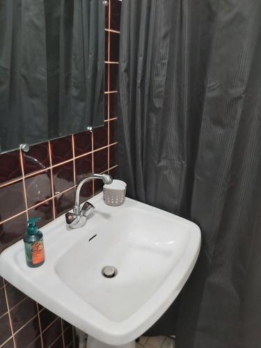 Baño con lavabo blanco y cortina de ducha negra en Studio RDC avec terrasse, en Ligny-en-Barrois