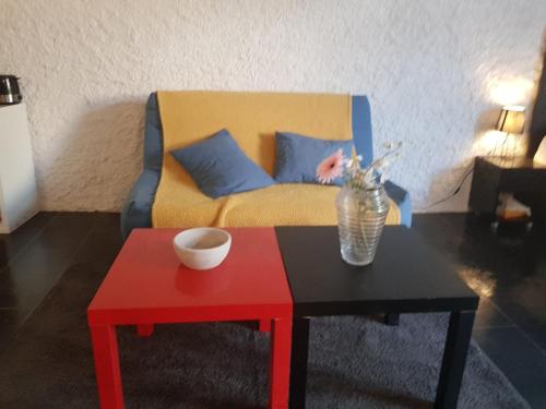 sala de estar con sofá y mesa roja en Studio RDC avec terrasse, en Ligny-en-Barrois