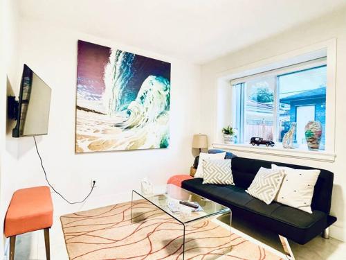 a living room with a black couch and a window at Charming 1BR near Metrotown DT Burnaby/ Vancouver in Vancouver