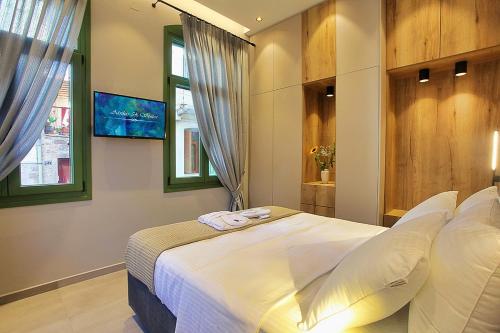 een slaapkamer met een groot wit bed en 2 ramen bij Atsiki's 54 apartments in Chios