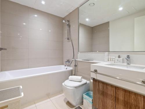 a bathroom with a tub and a toilet and a sink at Fantastic 1 BR in Park Point - Dubai Hills in Dubai