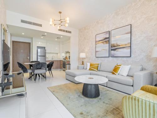 a living room with a couch and a table at Fantastic 1 BR in Park Point - Dubai Hills in Dubai