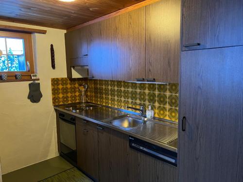 una pequeña cocina con fregadero y ventana en Haus Maran, en Urmein