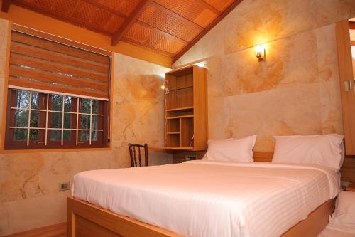 a bedroom with a bed and a window at The Pear Tree in Yercaud