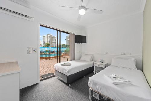 a hotel room with two beds and a balcony at Gold Coast Inn in Gold Coast