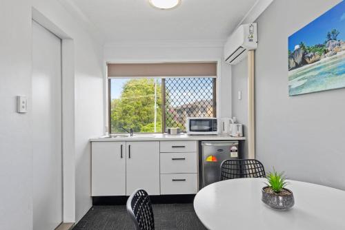 a kitchen with a table and a sink and a window at Gold Coast Inn in Gold Coast