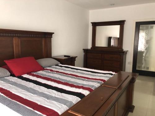 a bedroom with a bed with a red pillow and a mirror at CASA EJECUTIVA in Reynosa