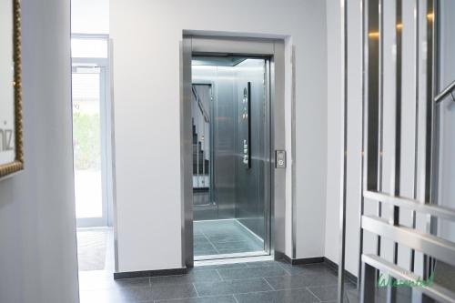 a glass shower in a hallway with a door at Hotel Wiesental Nähe Friedrichshafen in Meckenbeuren