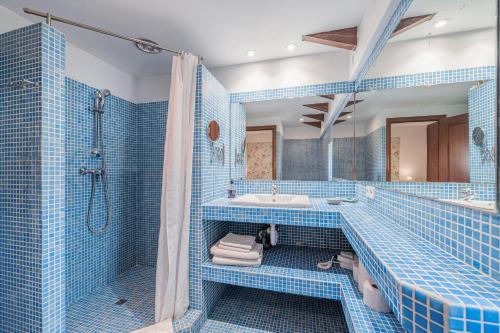 a blue tiled bathroom with a tub and a sink at Sa Llimonera de Binissalem in Binissalem