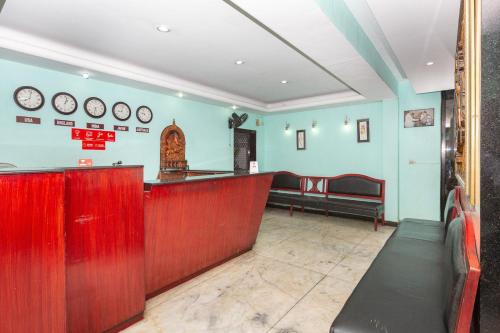 un bar en un restaurante con relojes en la pared en Collection O 5377 Hotel Raaj Bhaavan, en Chennai