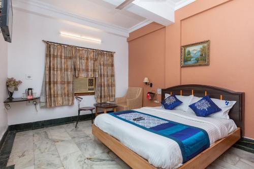 Habitación de hotel con cama y escritorio en Collection O 5377 Hotel Raaj Bhaavan, en Chennai