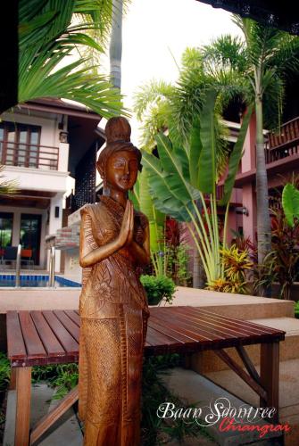 a statue of a woman standing next to a bench at Baan Soontree Resort in Chiang Rai