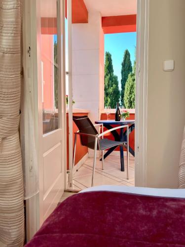 a bedroom with a bed and a table and a window at Villa Valdepian Apartments in Savudrija
