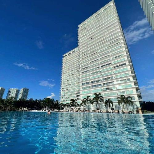 a large building with a large swimming pool in front of it at Peninsula Condominiums, Hotel Zone, PV in Puerto Vallarta