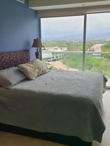 un letto in una camera con una grande finestra di Peninsula Condominiums, Hotel Zone, PV a Puerto Vallarta
