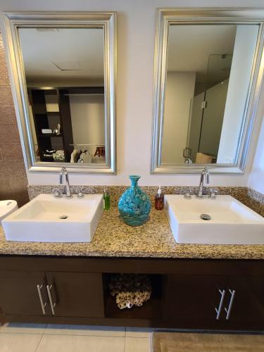 un bagno con due lavandini e un grande specchio di Peninsula Condominiums, Hotel Zone, PV a Puerto Vallarta