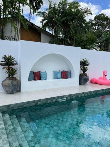 a swimming pool with pillows on a wall next to a swimming pool at Arau House in Arau