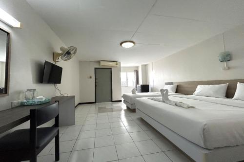 a large hotel room with two beds and a desk at Boonchai Mansion in Hat Yai