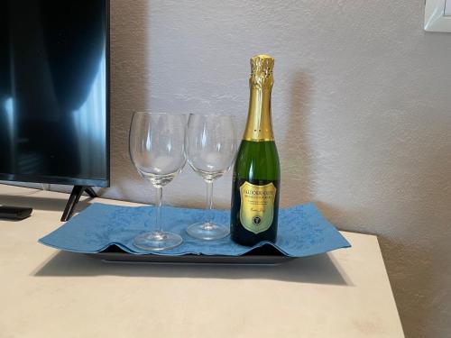 a bottle of champagne and two wine glasses on a tray at Hotel Lukas Vegetarian & Vegan in Viareggio
