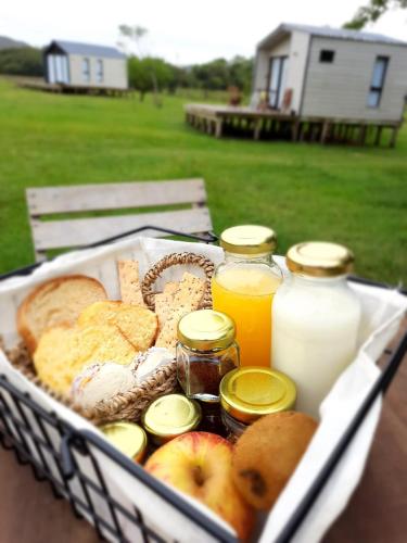 a basket of bread and juice and bottles of milk at Villa Pancha del Lunarejo in Sierra de Lunarejo