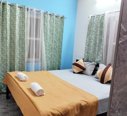 a bedroom with a bed with two towels on it at "SMS" HOME STAy in Kushālnagar