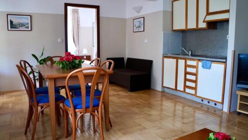a kitchen and living room with a table and chairs at Villa Valdepian Apartments in Savudrija