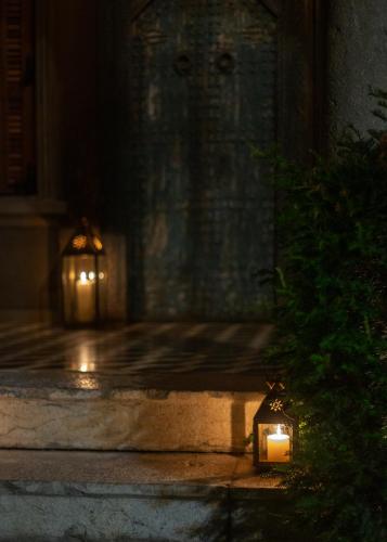a lit candle in front of a building at night at Life Gallery Hotel & Spa in Korçë