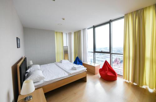 a bedroom with a bed and a large window at Sport Plaza Hotel & Apartments in Baku