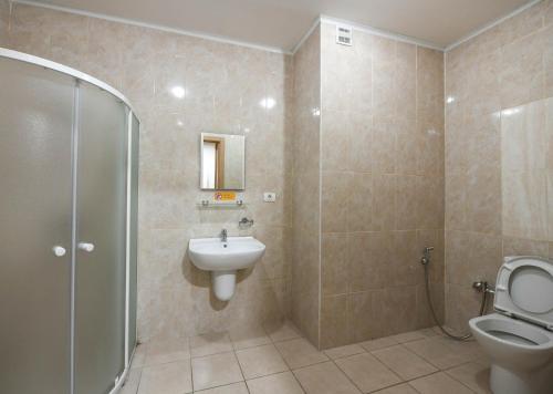 ein Bad mit einem WC, einem Waschbecken und einer Dusche in der Unterkunft Sport Plaza Hotel & Apartments in Baku