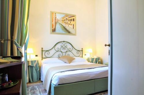 a bedroom with a bed and a painting on the wall at Villa Ducale Hotel & Ristorante in Dolo