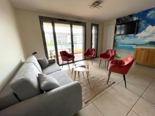 - un salon avec un canapé gris et des fauteuils rouges dans l'établissement Le calme dans le Triangle d'Or, à Annecy