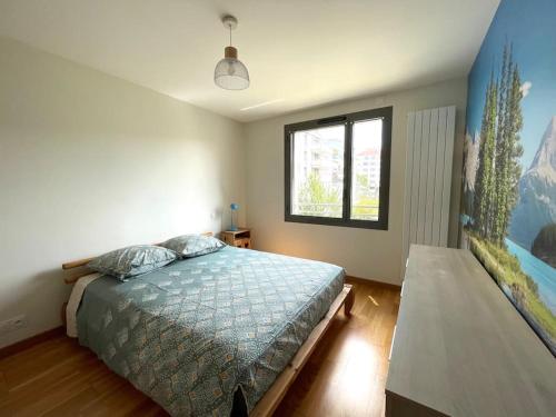 une chambre avec un lit et une fenêtre dans l'établissement Le calme dans le Triangle d'Or, à Annecy