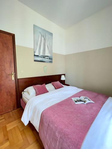 a bedroom with a large bed with a book on it at Villa Valdepian Apartments in Savudrija