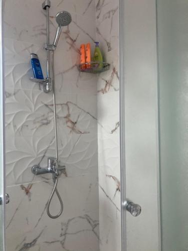 La salle de bains est pourvue d'une douche et d'une porte en verre. dans l'établissement бутиков апартамент Деси, à Pomorie