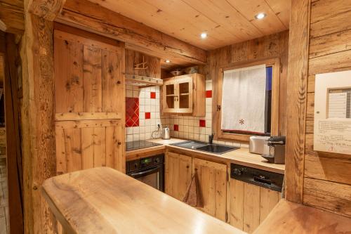 cocina con armarios de madera y encimera en La Ferme du Var, en La Clusaz