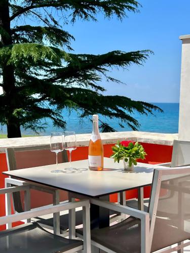 a table with two glasses and a bottle of wine at Villa Valdepian Apartments in Savudrija