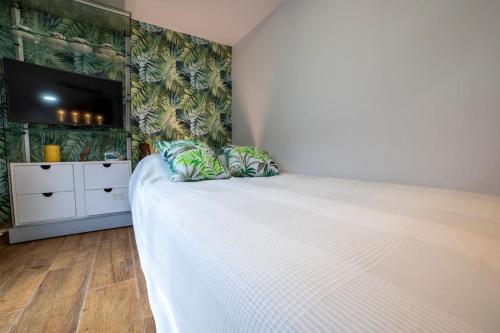 El Merendero في Ateca: غرفة نوم مع سرير أبيض كبير مع تلفزيون بشاشة مسطحة